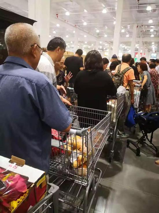Costco门店内，长长的结账队伍，不少老人在推车