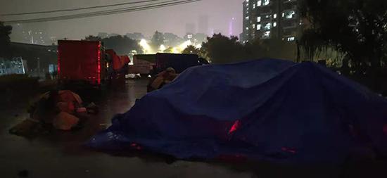 快递用油布盖住，底部的快递被指泡在水里