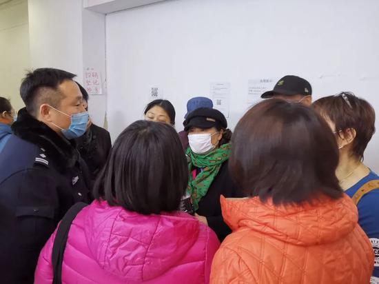 ▲11月24日，警察（左一）在蛋壳公寓总部维持秩序，鼓励情绪激动的维权房东拨打12345市长热线反映问题。