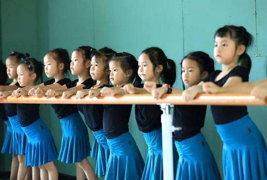 7月26日，孩子们在贵州省从江县一家舞蹈培训中心练习基本功。罗京来摄（中经视觉）